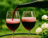 Rotwein wird in zwei Gläser gegossen, wobei sich Schaum bildet. Ein Hauch von Lambrusco Rotwein für einen schönen Abend.