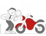 Mężczyzna z lupą dokonuje przeglądu motocykla.