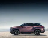Eleganckie, bordowe infiniti auto z czarnym dachem na tle górskiego krajobrazu.