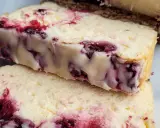 Dwa kawałki pysznego sernika z wiśniami, z widocznymi kawałkami owoców w kremowej masie.