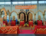 Allestimento per il festival dell'oriente Rimini con statue induiste, archi in legno e un grande striscione "Unione Induista Italiana".