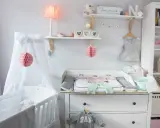 Eine liebevoll eingerichtete Hemnes Wickelkommode mit Babykleidung, Spielzeug und Deko.