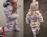 Dwie dziewczynki w kombinezonach zimowych: jedna w fioletowym, druga w kwiecistym.