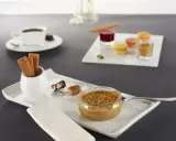 Un café gourmand avec diverses mignardises : verrine caramélisée, macarons, biscuits, chocolats. Idéal pour des recettes de mignardises pour café gourmand.