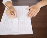 Persona completando un examen de opción múltiple, preparándose para el teórico carnet C.