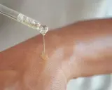 Kropla serum z niacynamidem 5% spada na skórę, nawilżając ją i odżywiając.