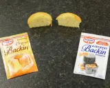 Zwei Päckchen Dr. Oetker Backin, einmal Original und einmal für den Airfryer, liegen neben zwei halbierten Küchlein. Perfekt für schnelles Backen mit Mehl und Backpulver.