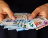 Manos sostienen billetes de 500 pesos, una forma de sacar dinero sin tarjeta.