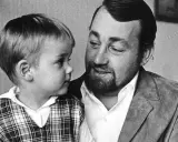 Cornelis Vreeswijk med sitt barn i en rutig väst. En varm stund mellan far och son.
