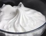 Merengue italiano esponjoso y brillante en un bol de cristal, listo para decorar postres.