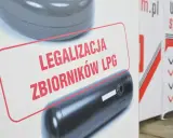 Zbiornik LPG z napisem "Legalizacja zbiorników LPG" na tle innego zbiornika.