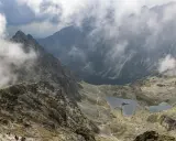 Widok na skaliste zbocza i dwa jeziora w Tatrach, rysy od strony polskiej. Mgła otula szczyty.