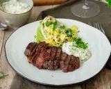 En saftig grillad ryggbiff serveras med krispig sallad, grillad kål och en krämig sås.