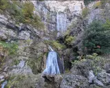 Impresionante cascada en la ruta de las cascadas Bogarra, cayendo por una pared rocosa con vegetación otoñal.