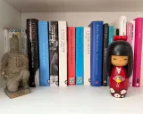 Statua guerriero terracotta e una collezione di libri di Tiziano Terzani, tra cui "La fine è il mio inizio" e "Un altro giro di giostra".