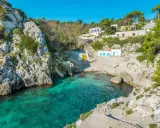 Baia incantevole con acque cristalline, perfetta per un itinerario Puglia 3 giorni. Case bianche e rocce a picco sul mare.