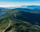 Malowniczy widok ze Skrzycznego na Beskidy. Góry pokryte lasami, a w oddali morze chmur.