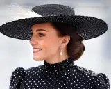 Księżna Kate w eleganckiej, czarno-białej sukience w grochy i stylowym kapeluszu.