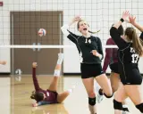 Jubelnde Volleyballerinnen nach einem Punkt. Eine Spielerin liegt am Boden, während andere jubeln. Ein perfekter Moment im warm up volleyball.