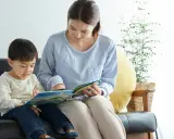 Madre e hijo comparten un momento de lectura, aprendiendo juntos. Las frases de disciplina pueden ser parte de las lecciones de vida que se transmiten.