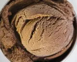 Une généreuse boule de glace au chocolat, crémeuse et givrée, dans un bol métallique.