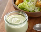 Cremiges Dressing in einem Glas, bereit für einen köstlichen veganen Caesar Salad mit Croutons und Parmesan-Alternative.