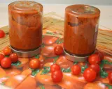 Zwei Schraubgläser mit selbstgemachter Tomatensauce, umgeben von frischen Tomaten und Spaghetti. Perfekt zum Tomatensauce einkochen.