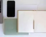 Laptop, telefon, zeszyt i ołówek czekają na nowe pomysły. Czas na wypełnienie pustej przestrzeni, czyli wakat w kreatywności.