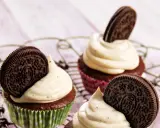 Drei leckere Oreo Muffins mit cremiger Glasur und einem ganzen Oreo-Keks darauf, auf einem Gitter.