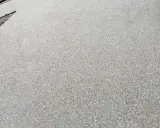 Superficie de hormigón desactivado con pequeñas piedras incrustadas, creando una textura rugosa y antideslizante.