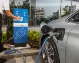 Un uomo collega un'auto elettrica a una colonnina di ricarica BMW i. Un passo verso il calcolo risparmio auto elettrica.