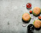 Tre saftiga hamburgare, en skål med ketchup, tomater, rödlök och en läsk med is. Perfekt för en mysig kväll på vår western grillhouse.