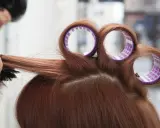 Profesjonalny styling włosów: lokówka i szczotka tworzą objętość.