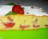 Wilgotne ciasto na oleju z owocami, posypane cukrem pudrem, z truskawką na wierzchu.