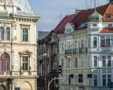 Kamienice na rynku w Bielsku-Białej, z bogatymi zdobieniami i różnorodnymi dachami, tworzą malowniczy widok.