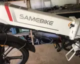 Biały rower elektryczny SAMEBIKE, z widocznym napisem marki. Wspomaganie nie działa, co jest problemem dla właściciela.