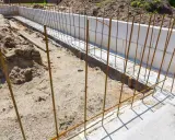 Zbrojenie fundamentu w trakcie budowy, stalowe pręty tworzą ruszt dla przyszłego betonu.