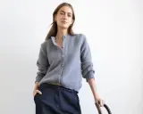 Elegancka kobieta w szarym kardiganie i ciemnych spodniach. Idealne szary kardigan stylizacje na co dzień.