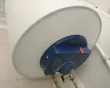 El termo gotea por abajo, mostrando una fuga de agua en la parte inferior del calentador.