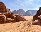Pustynia w Jordanii, Wadi Rum. Piaskowe wydmy i skalne formacje pod błękitnym niebem.