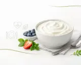 Czy skyr jest zdrowy? Kremowy jogurt, jagody, truskawka i mięta na białym tle. Obok ikony serca i talerza.