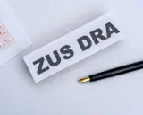 ZUS DRA na papierze, obok czarne pióro. Dokumenty do wypełnienia.