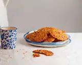 Deliciosas galletas de jengibre con trozos de nuez, servidas en un plato azul y blanco. Perfectas para acompañar un café.