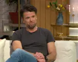 Peter Magnusson sitter i en soffa, kanske redo att prata om sina filmer och tv-program.