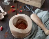 Mortier en bois avec une pâte épicée javanaise, piments rouges séchés et des cuillères en bois. Recette à venir.