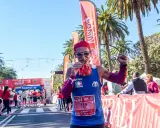 Lächelnder Läufer mit Medaille und rotem Kopftuch feiert seinen Erfolg beim Malaga Marathon.