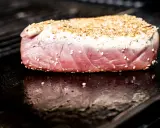 Surowy stek z tuńczyka w sezamie na rozgrzanym grillu.
