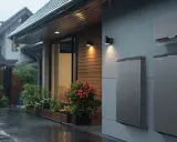 Deszczowa noc. Na ścianie domu zamontowane są nowoczesne magazyny energii. Zastanawiasz się, magazyn energii 5 kw na ile wystarczy?
