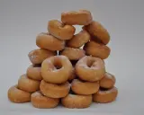 Pile de donuts dorés saupoudrés de sucre, parfaits pour une recette facile de donuts maison.