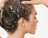 Frau wäscht sich die Haare, Schaum im Haar deutet auf die pflegende panthenol wirkung hin.